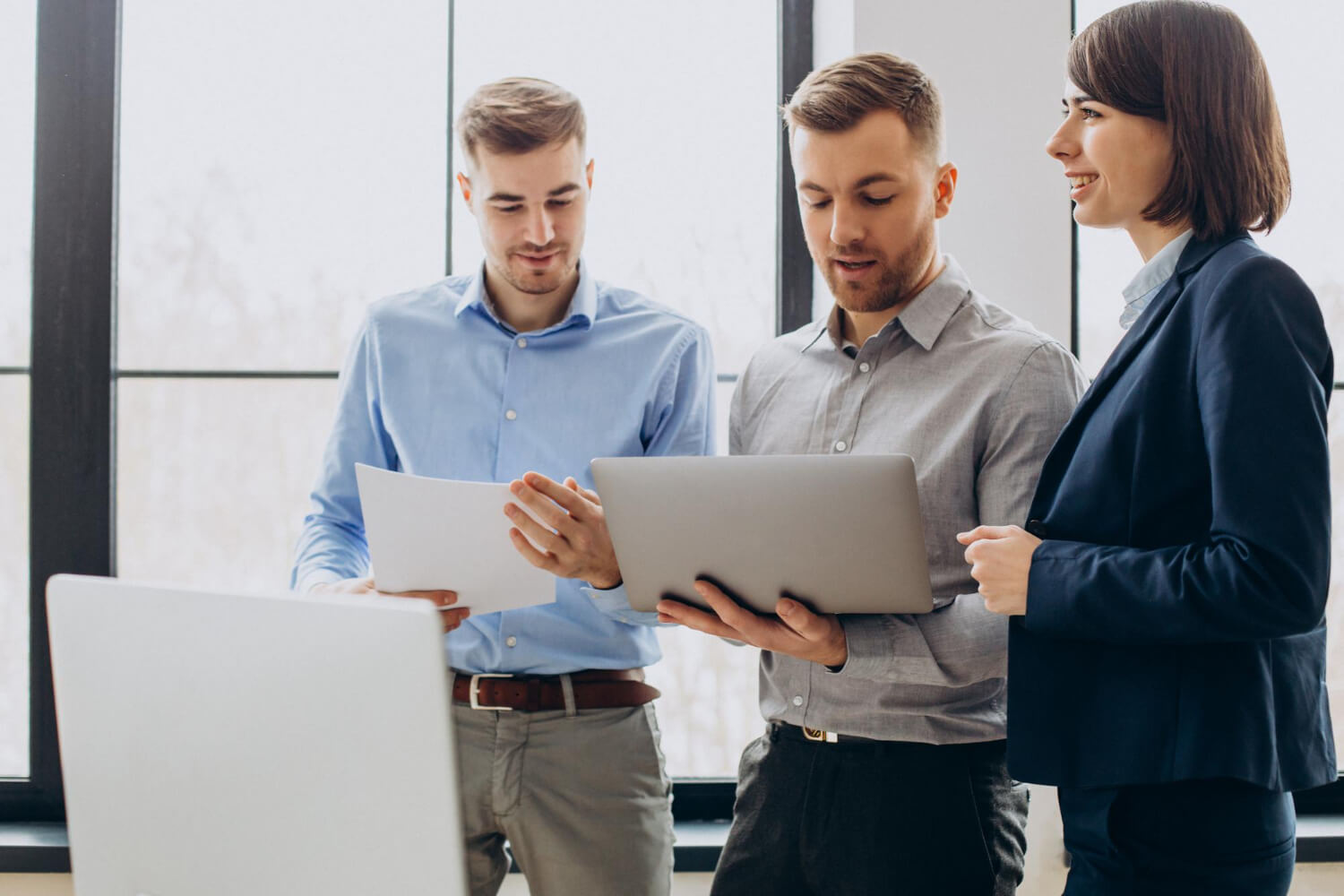 Three business people discussing about GDPR in front of a window